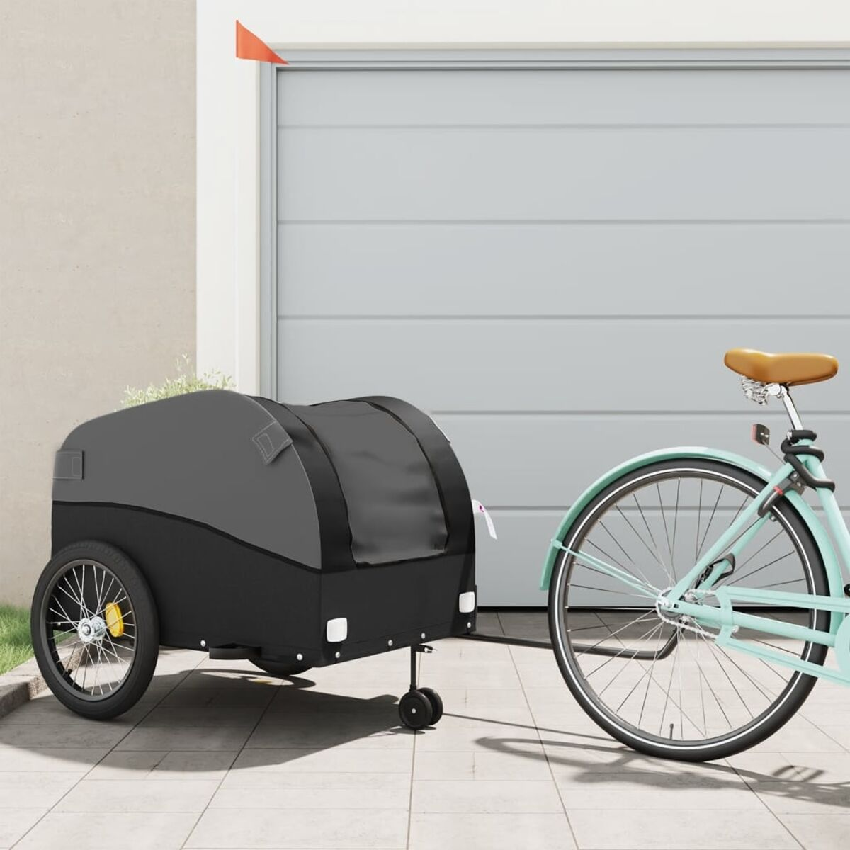 Fahrradanhänger an einem Fahrrad befestigt. Grauer Container und eine offene Garagentür im Hintergrund.