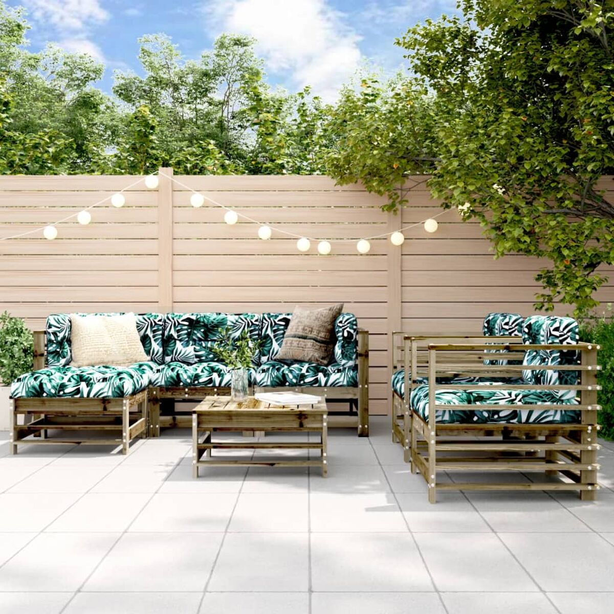 Ein Terrassenset mit Sofa und Stühlen mit tropischen Blattmusterkissen.