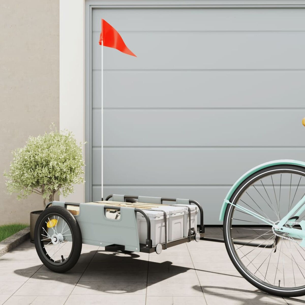 Grauer Wagen an einem Fahrrad befestigt. Garage im Hintergrund.