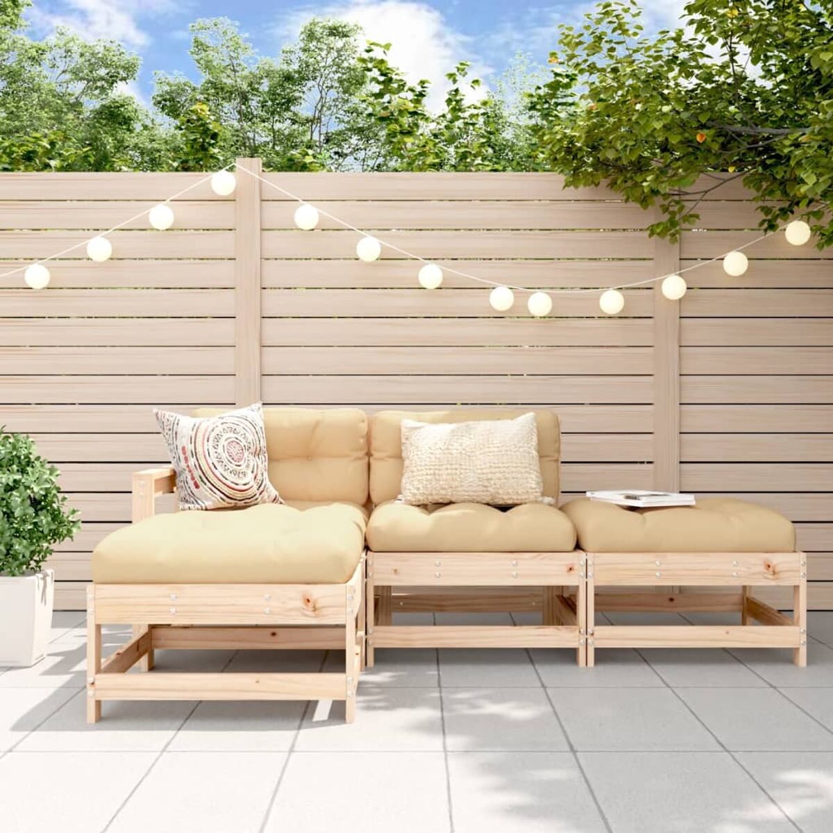 Outdoor-Ecksofa mit hellen Kissen auf einer Terrasse, mit einem Zaun und Bäumen im Hintergrund.