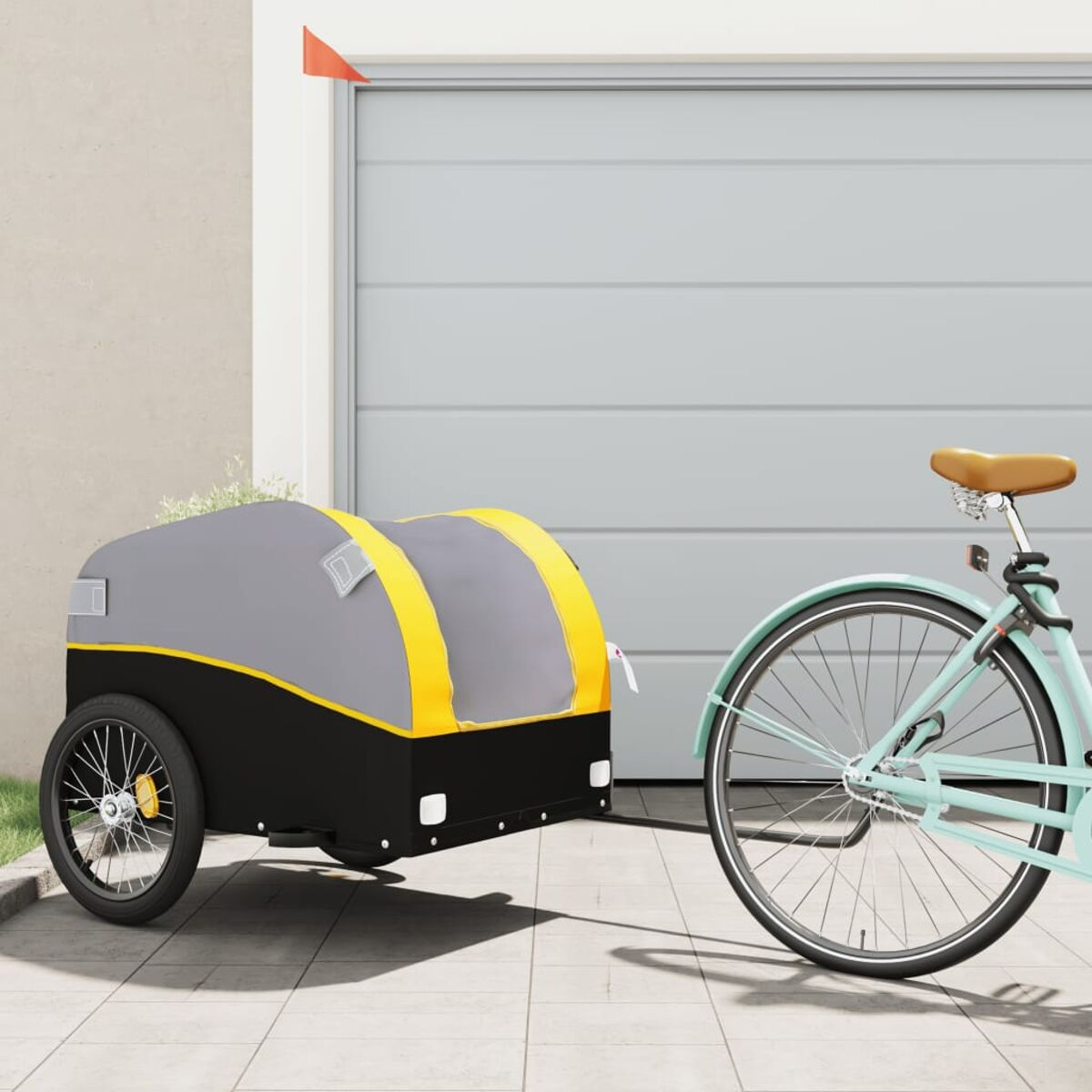 Fahrrad und Anhänger geparkt vor Garage. Anhänger grau und schwarz mit gelben Akzenten.