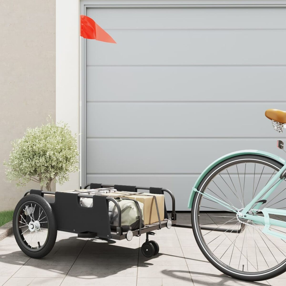 Ein Fahrrad zieht einen schwarzen Anhänger mit Ladung. Rote Fahne am Anhänger.
