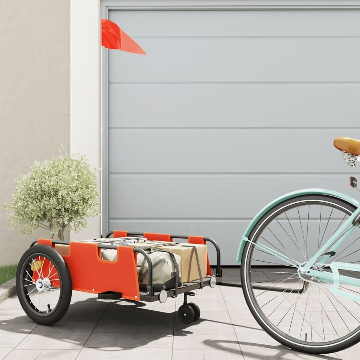 Ein Fahrrad mit rotem Anhänger vor einer Garage geparkt. Rote Flagge am Anhänger.