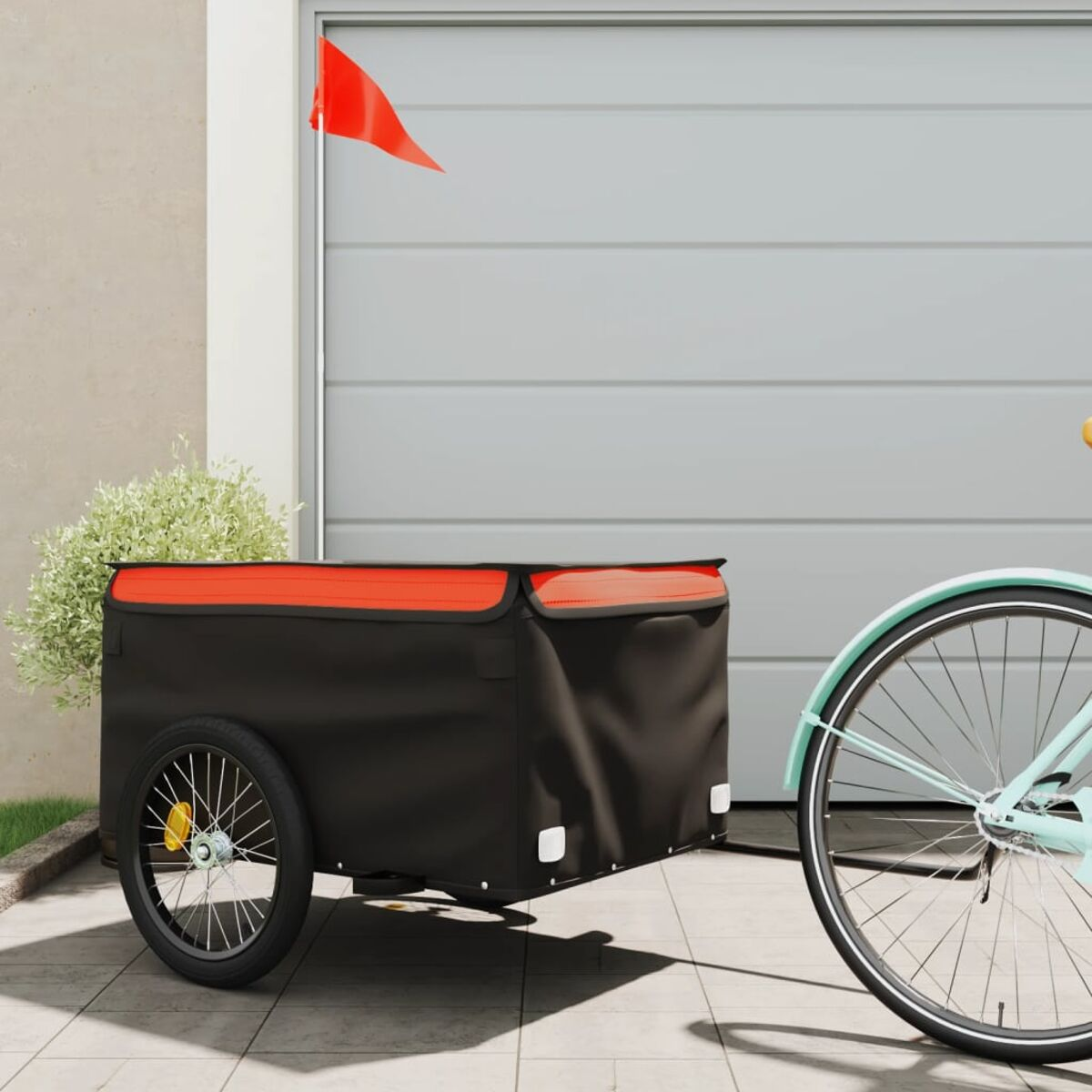 Ein Fahrrad zieht einen schwarzen Anhänger. Eine rote Fahne ist am Anhänger befestigt.