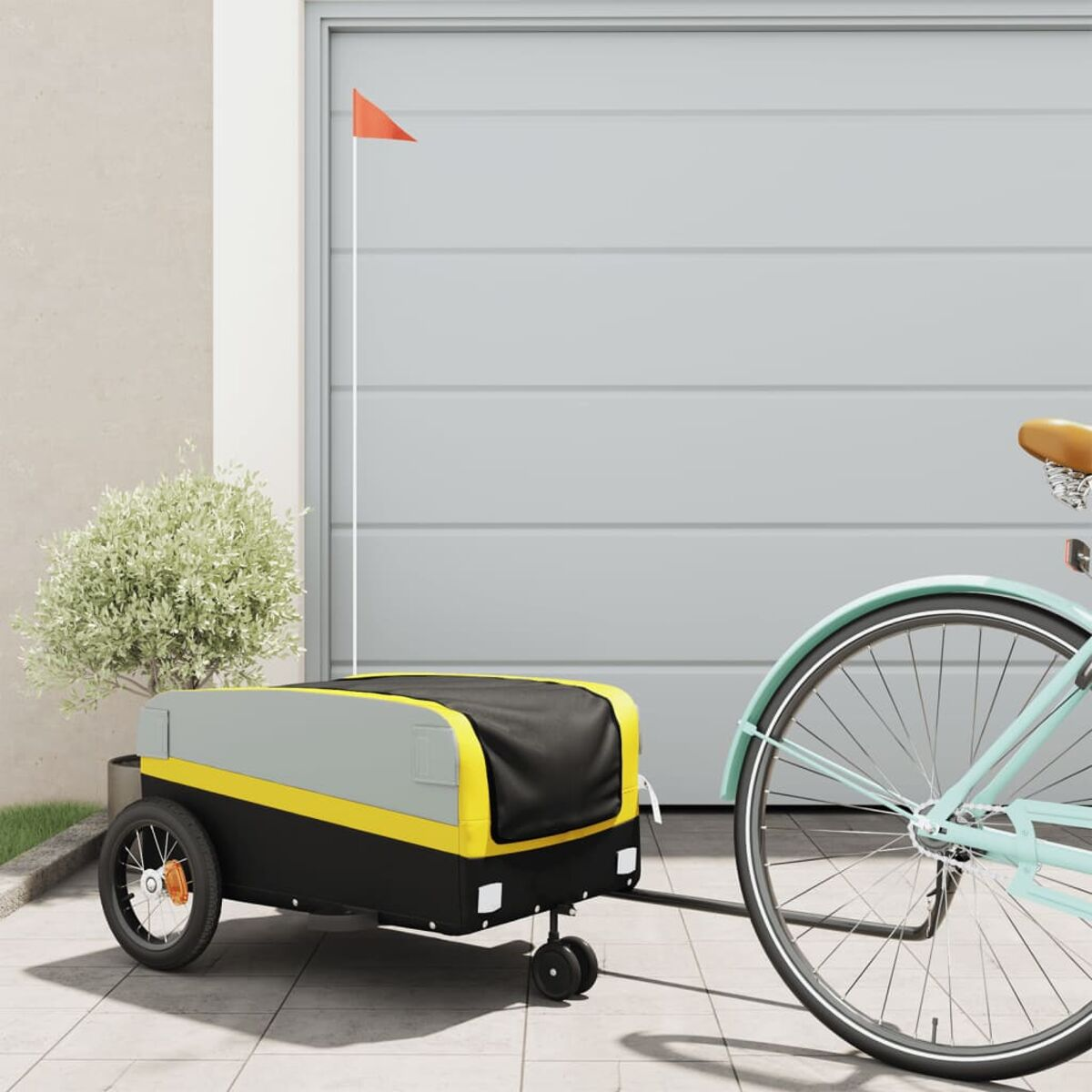 Ein Fahrrad und Anhänger parken neben einer Garage, mit roter Flagge am Anhänger.