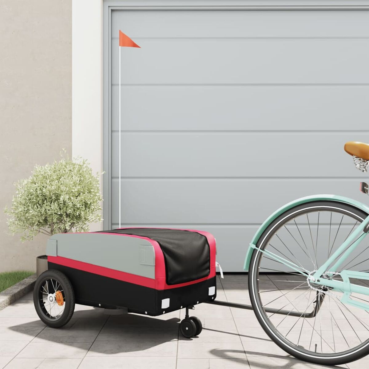 Fahrrad mit Anhänger, rote Fahne am Anhänger. Graue Garagentür im Hintergrund.