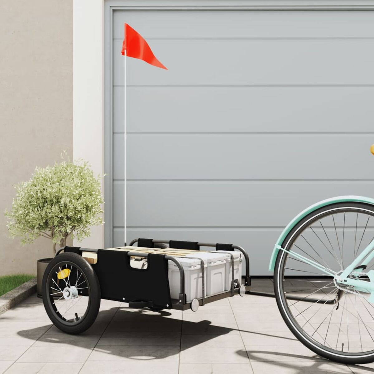 Fahrradanhänger mit roter Flagge und schwarzem Rahmen. An einem Fahrrad befestigt.