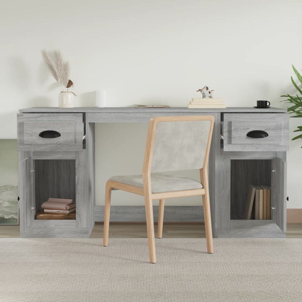 Ein grauer Holzschreibtisch mit Stuhl. Der Schreibtisch hat Schubladen und einen Schrank. Bücher und Pflanze.