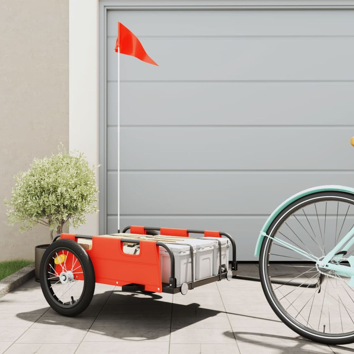 Roter Fahrradanhänger mit weißen Boxen, rote Fahne am Fahrrad. Im Hintergrund ein Garagentor.