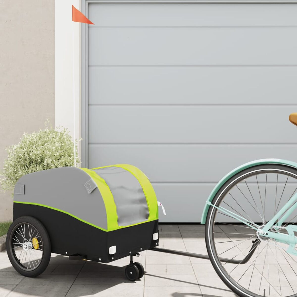 Anhänger an einem Fahrrad befestigt, grau und schwarz mit grüner Verkleidung.