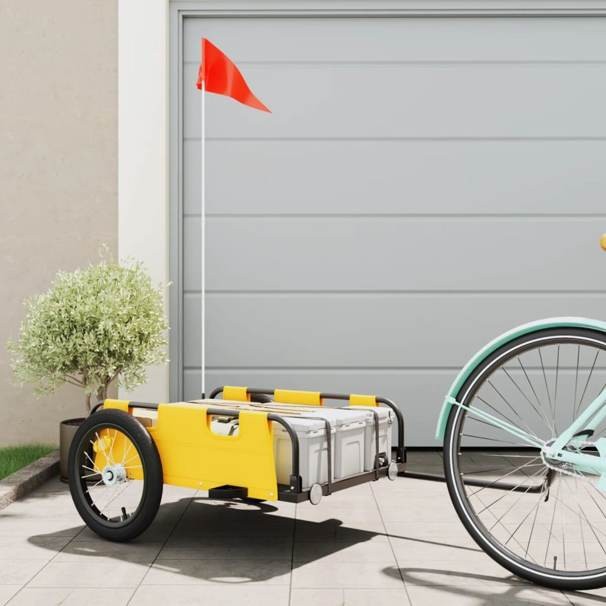 Ein gelber Lastenanhänger mit Fahrrad. Rote Flagge am Anhänger.