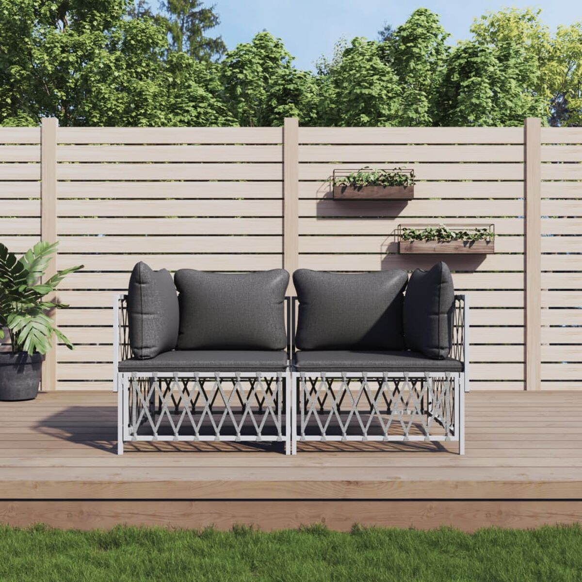Außensitzgruppe: Zweisitzer-Sofa mit grauen Kissen, Holzterrasse, grünes Gras und Holzzaun.