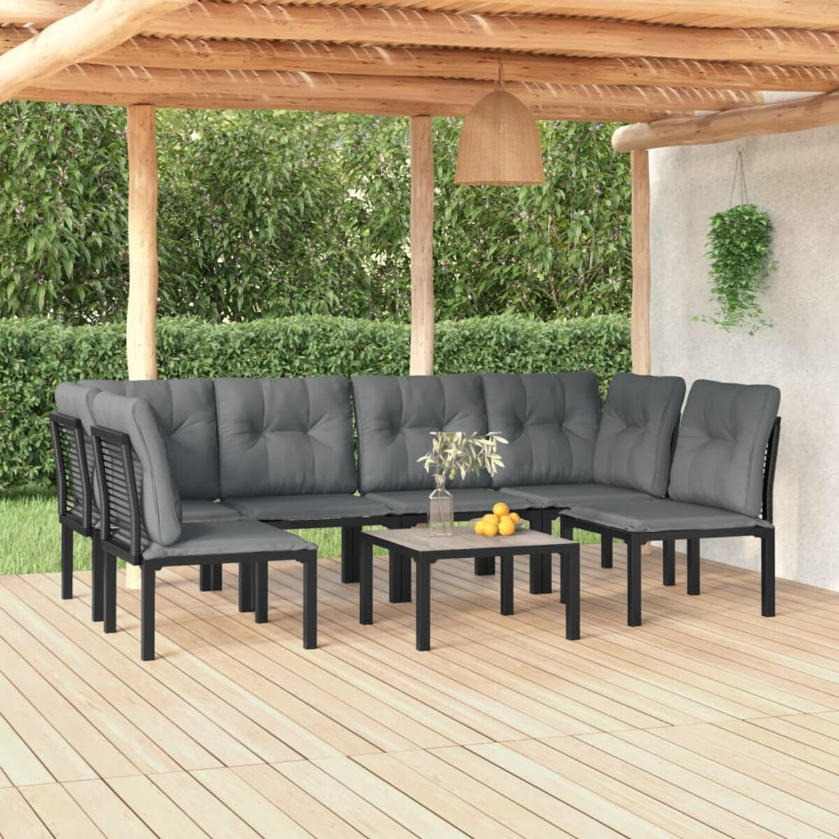 Eine Sitzgruppe im Freien mit Sofa, Stühlen und einem Couchtisch unter einer Holzpergola.