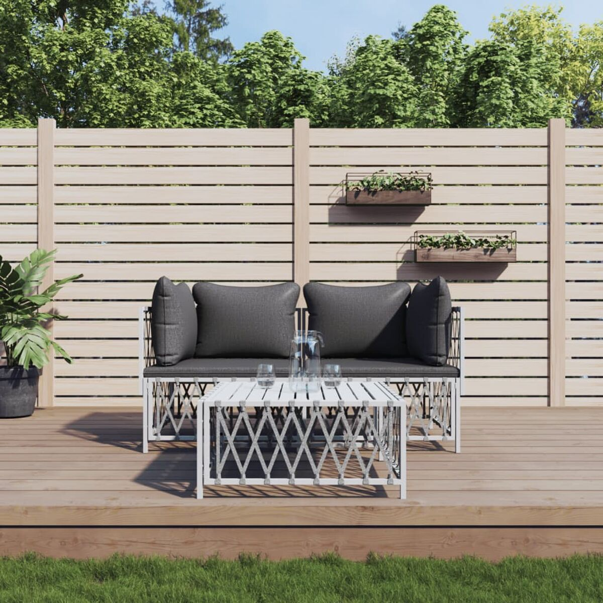 Terrassenmöbel-Set mit weißem Tisch, Sofa und zwei Stühlen auf einer Holzterrasse.