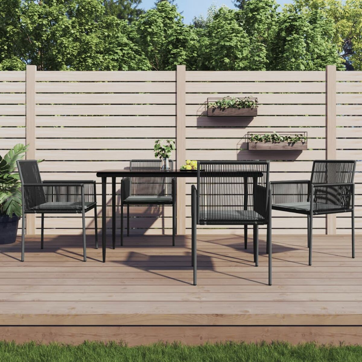 Essgruppe für draußen mit schwarzem Tisch und Stühlen auf Holzterrasse mit Blumenkästen.