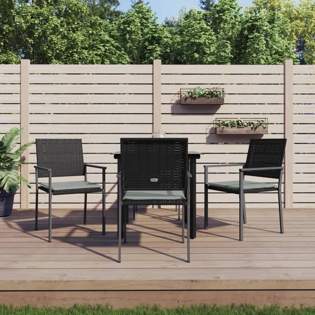 Essgruppe für den Außenbereich mit Tisch und drei Stühlen auf Holzterrasse.