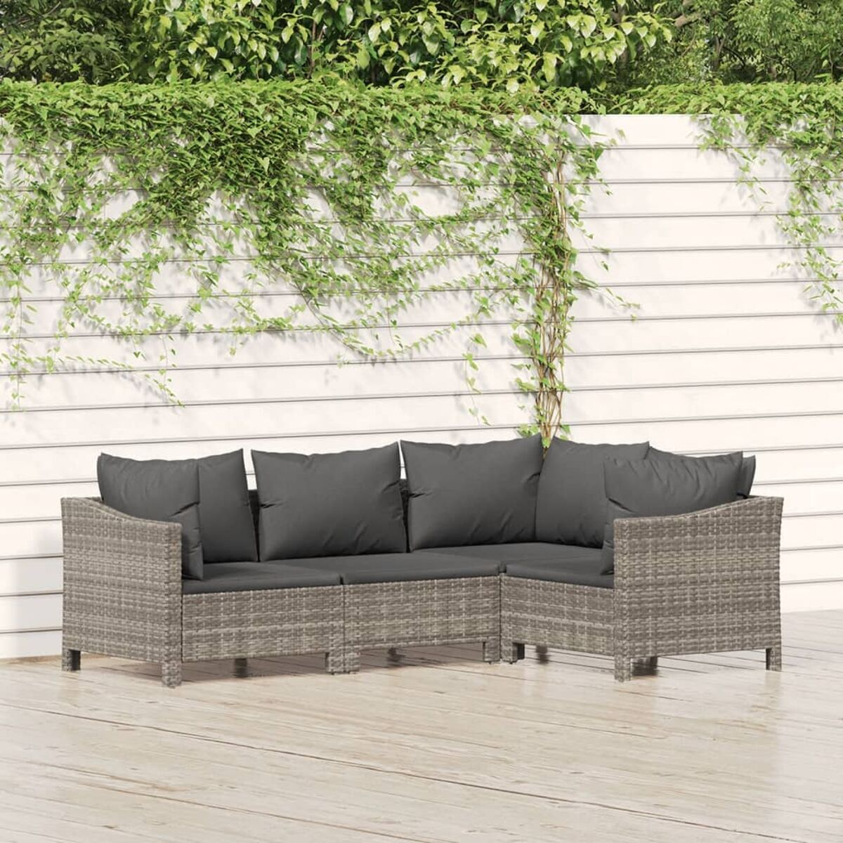 Graues Ecksofa mit dunklen Kissen, auf einem Holzdeck platziert.