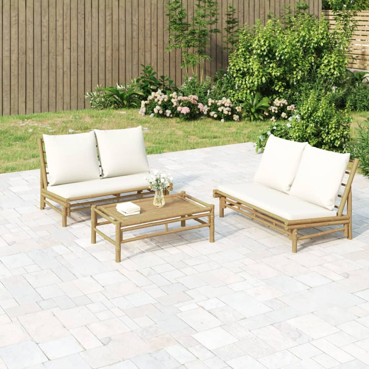 Eine Terrassengarnitur mit zwei Sofas, einem Couchtisch und zwei Kissen, alles auf einer Steinterrasse.