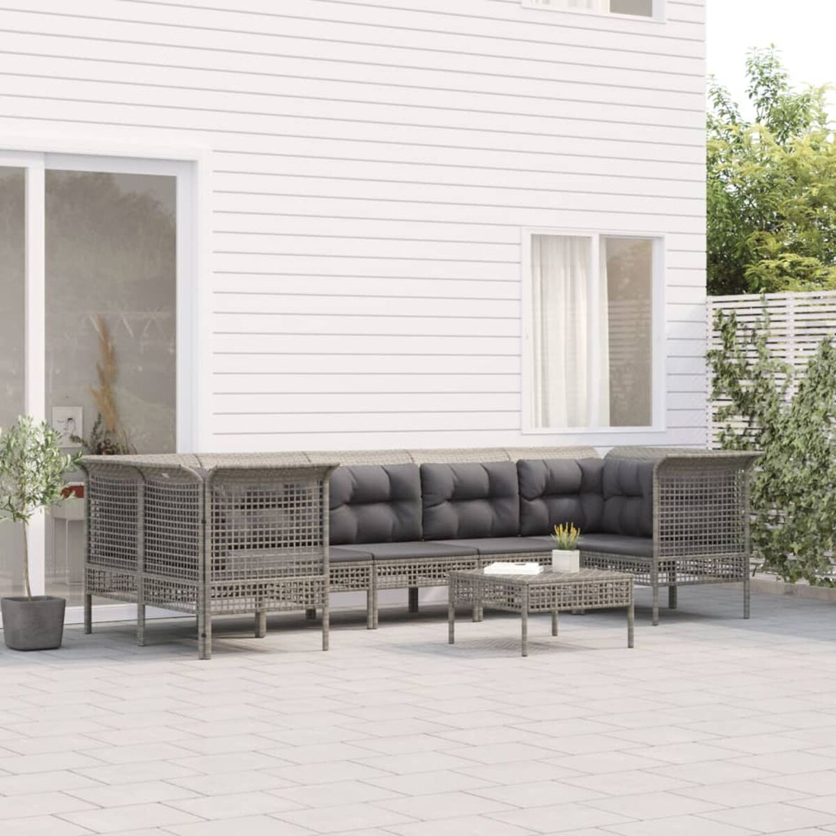 Ein Set grauer Gartenmöbel auf einer Terrasse.