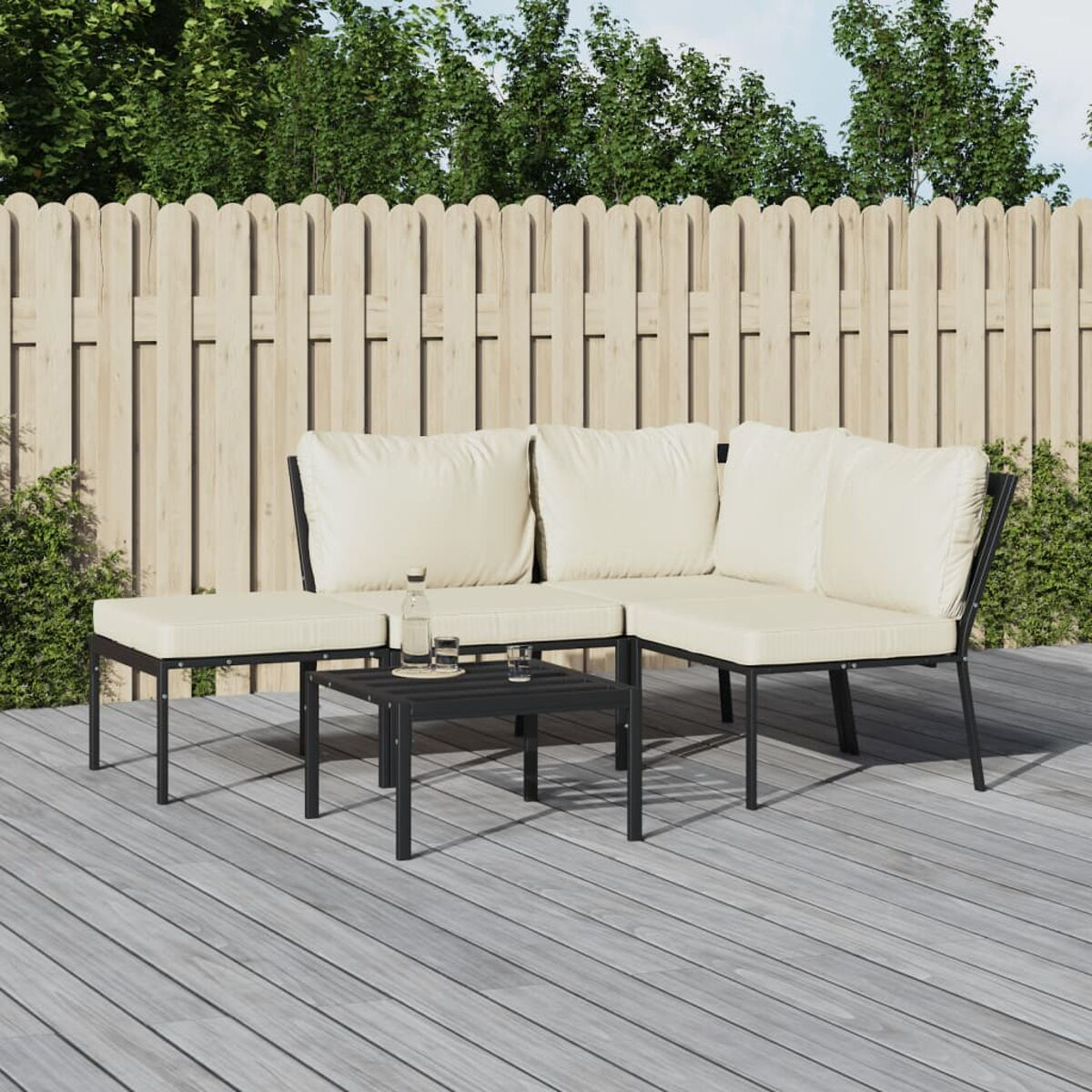 Outdoor-Ecksofa mit cremefarbenen Kissen und schwarzem Metallrahmen sowie einem Couchtisch. Holzterrasse und Zaun.