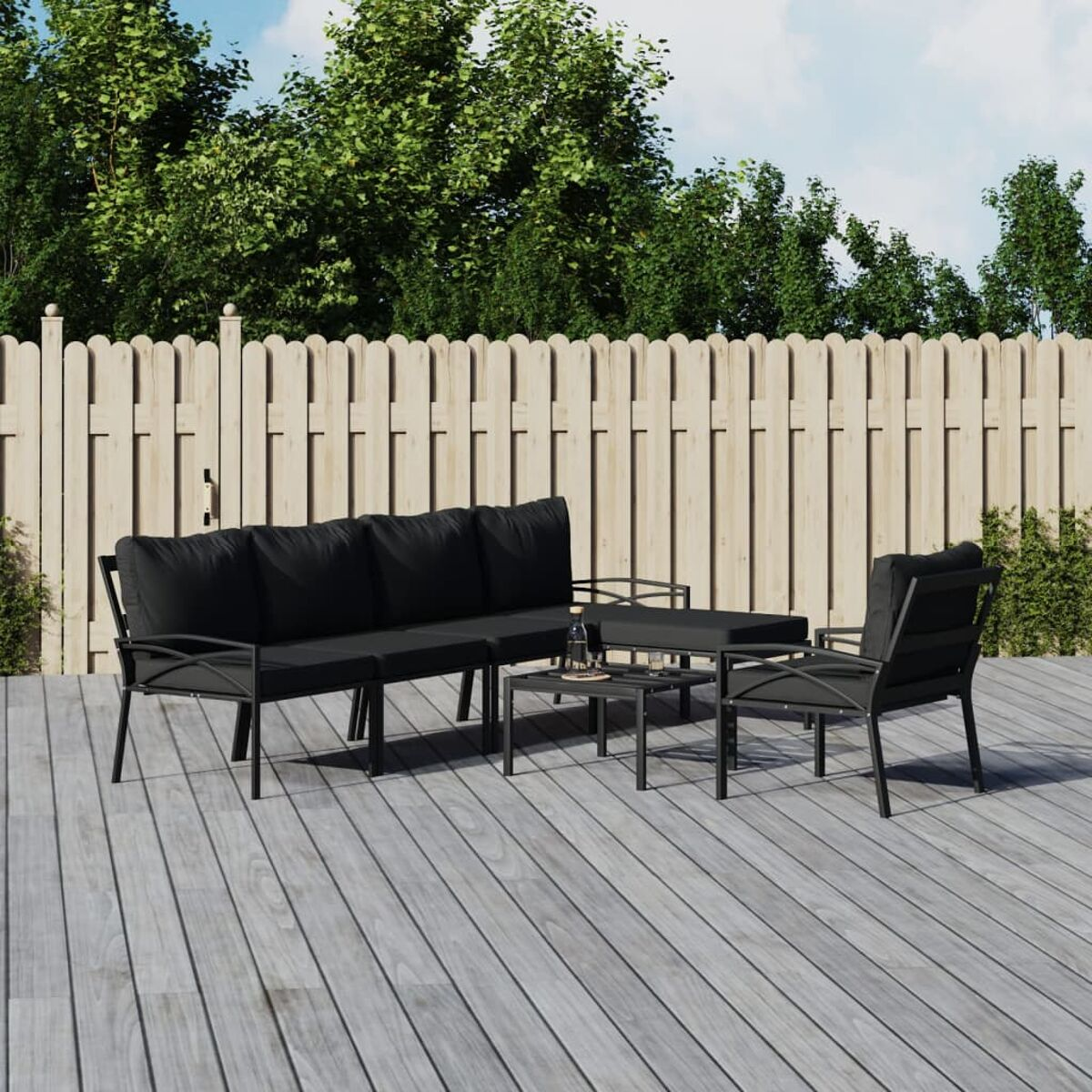 Outdoor-Sofa-Set auf einer Holzterrasse, mit einem schwarzen Tisch und Holzzaun im Hintergrund.