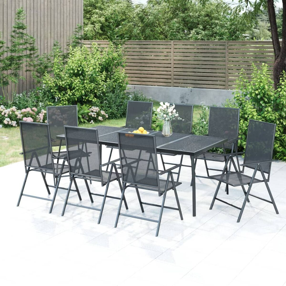 Essgruppe für draußen. Enthält einen Tisch, acht Stühle und eine Gartenkulisse.