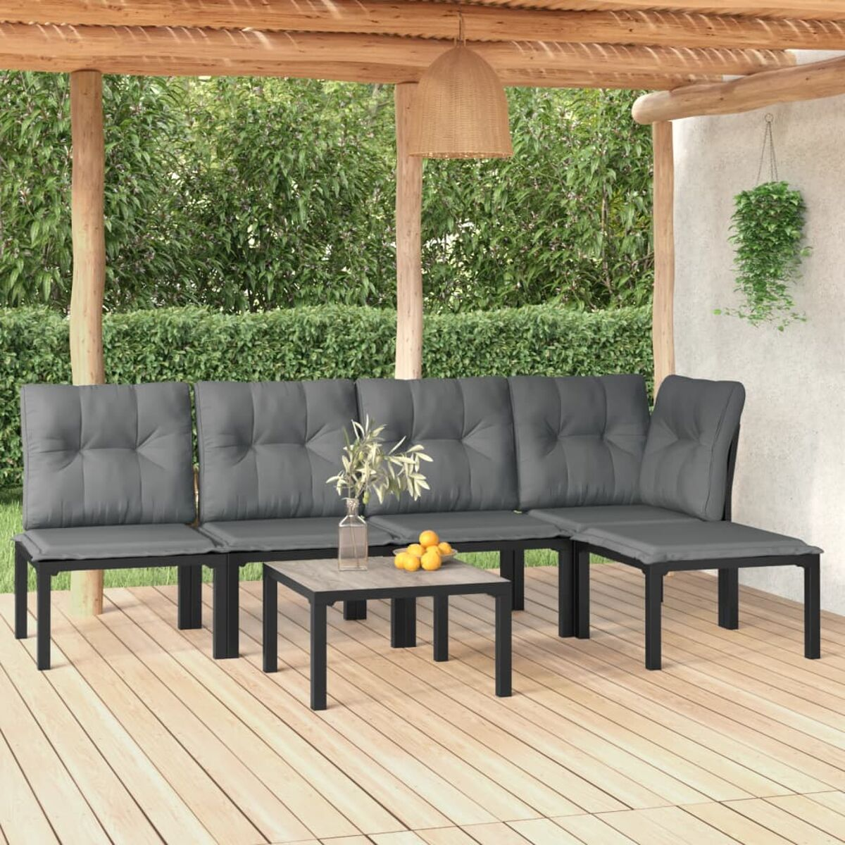Gartencouch mit grauen Kissen und einem kleinen Tisch mit Blumenvase auf einer Terrasse.