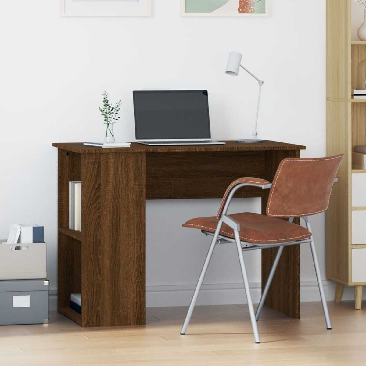 Ein brauner Schreibtisch mit Laptop und Stuhl. Eine Vase mit Blumen steht auf dem Tisch.