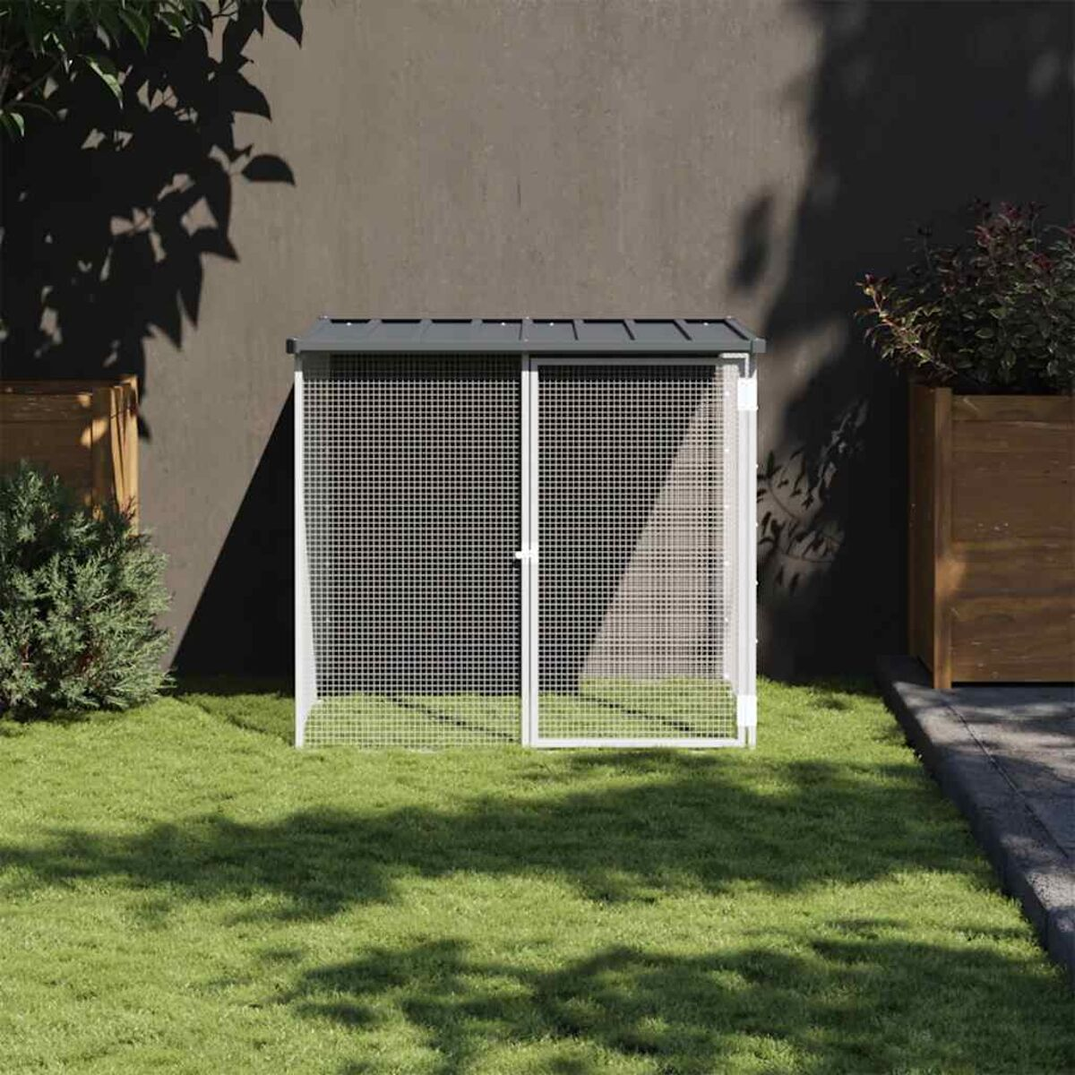 Ein kleiner Haustierkäfig aus weißem und grünem Metall, in einer Gartenszene.