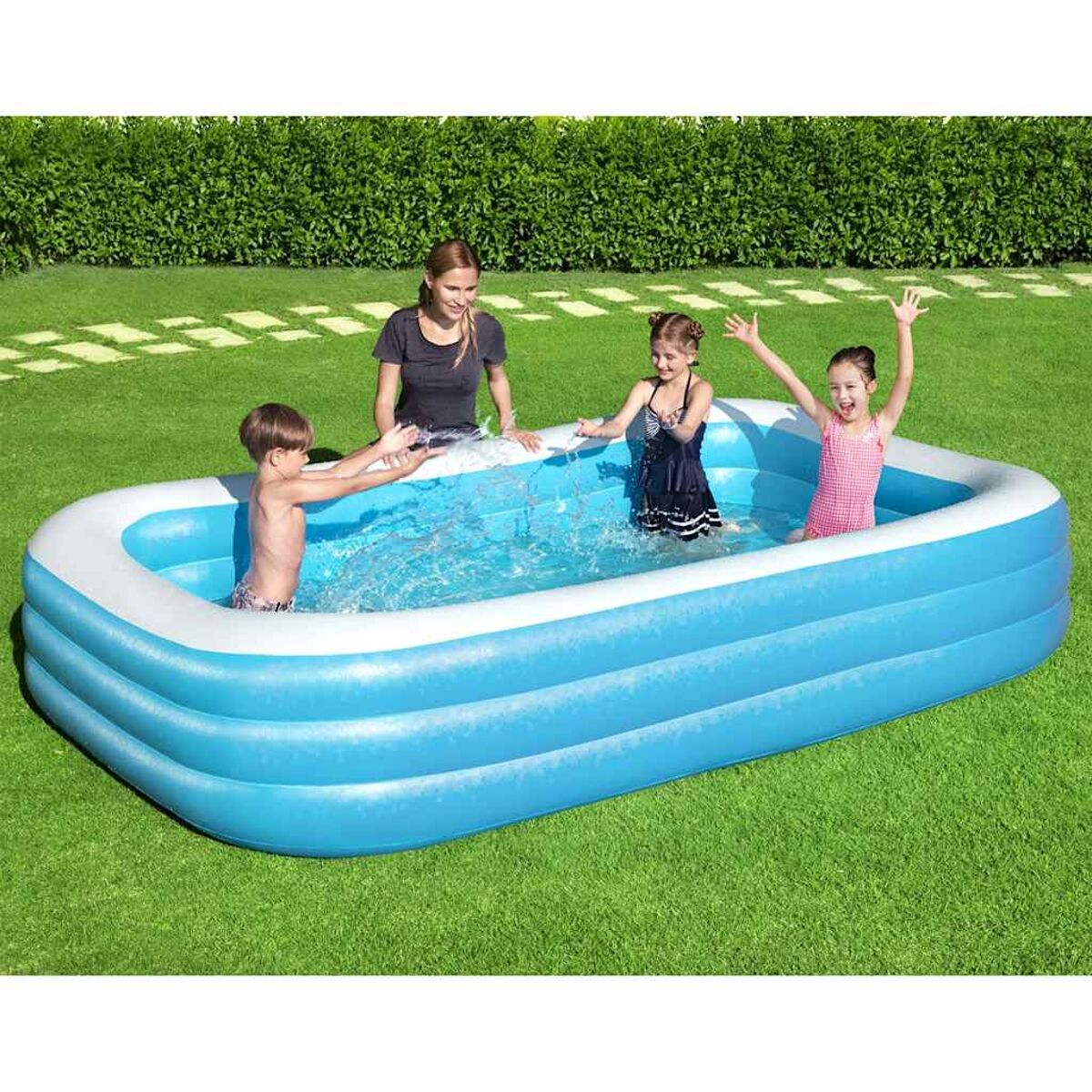 Vier Personen in einem blauen rechteckigen Pool. Eine Frau steht. Drei Kinder spielen im Wasser.