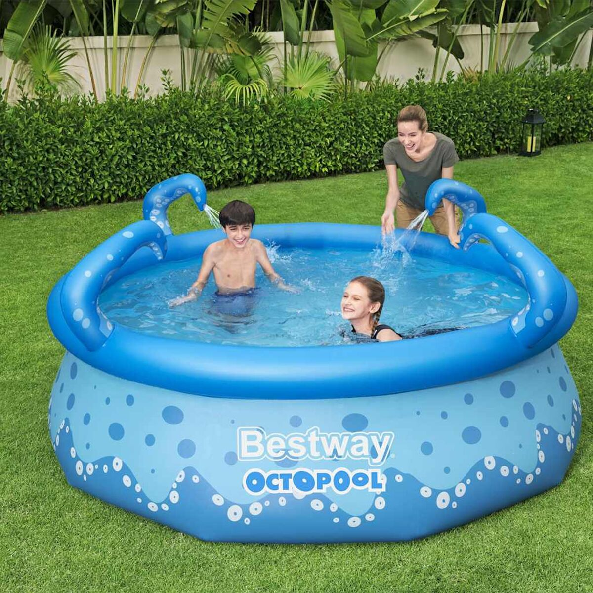 Kinder spielen in einem aufblasbaren Pool im Blau-Oktopus-Design, während eine Frau von oben Wasser hineingießt.