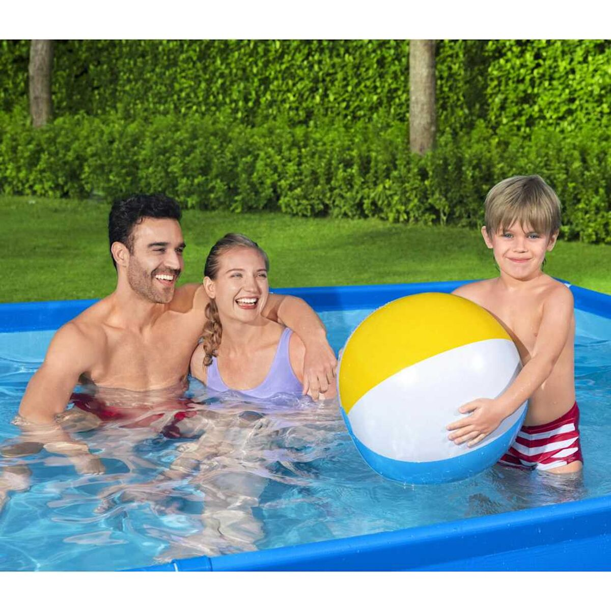 Familie im Pool mit Ball. Mann, Frau und Kind lächeln.