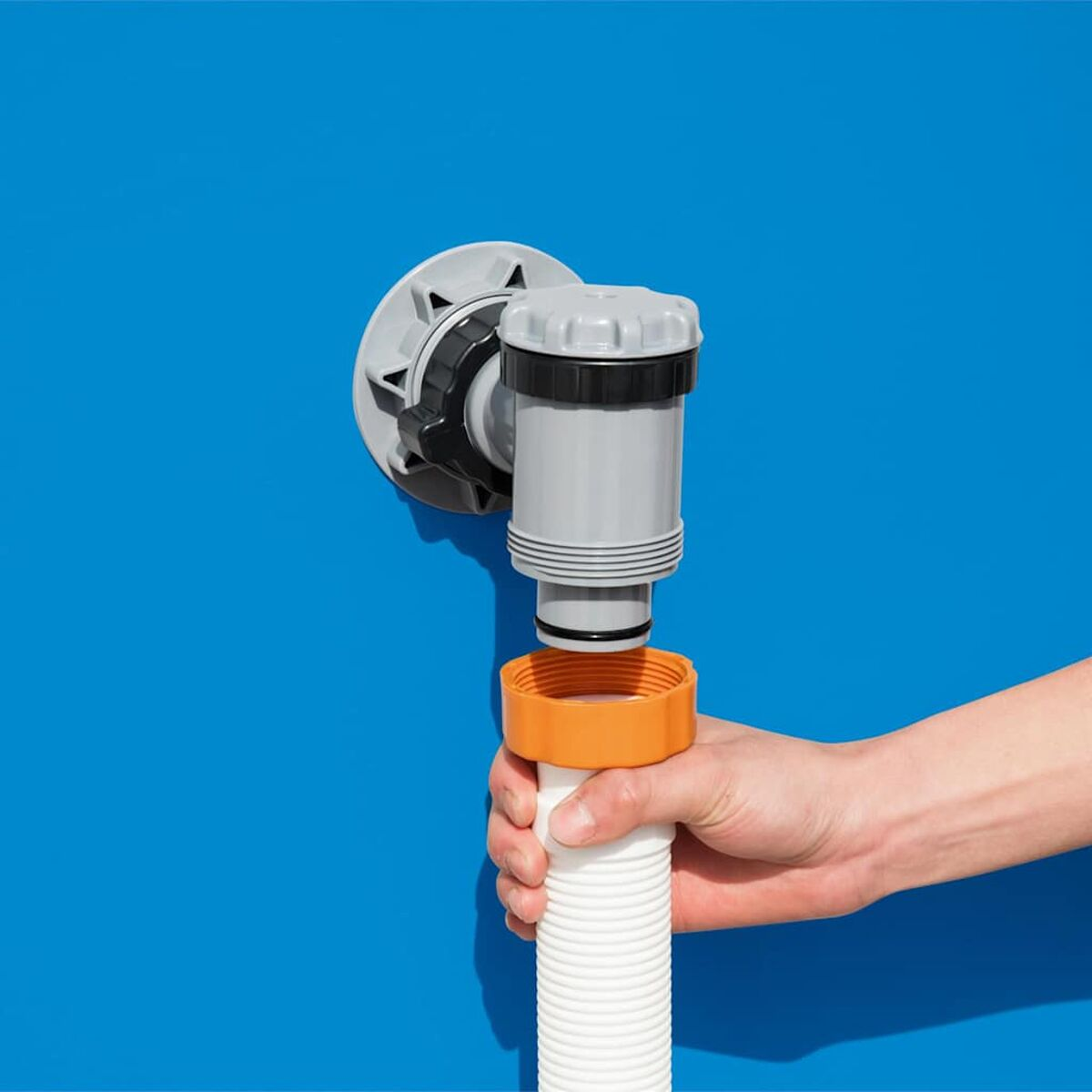 Nahaufnahme eines Pool-Skimmers. Graue und schwarze Komponenten. Blaue Poolwand und orangefarbene Armaturen.