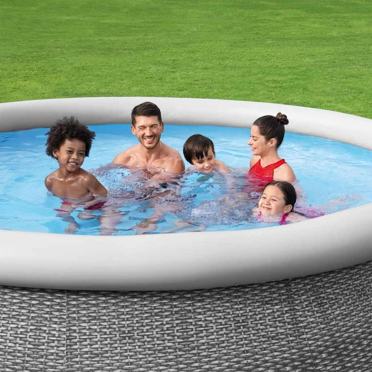 Gruppe von Leuten in einem Pool. Es sind zwei Erwachsene und drei Kinder. Der Pool hat graue Wände.