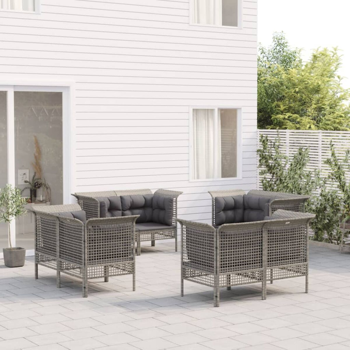 Sitzgruppe im Freien mit vier grau gepolsterten Stühlen und einem grau gepolsterten Sofa.