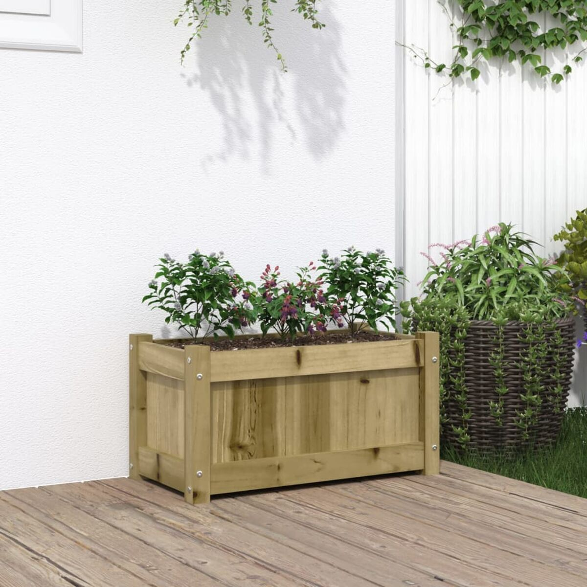 Ein Holzpflanzkasten mit Pflanzen auf einem Holzdeck neben einer weißen Wand.