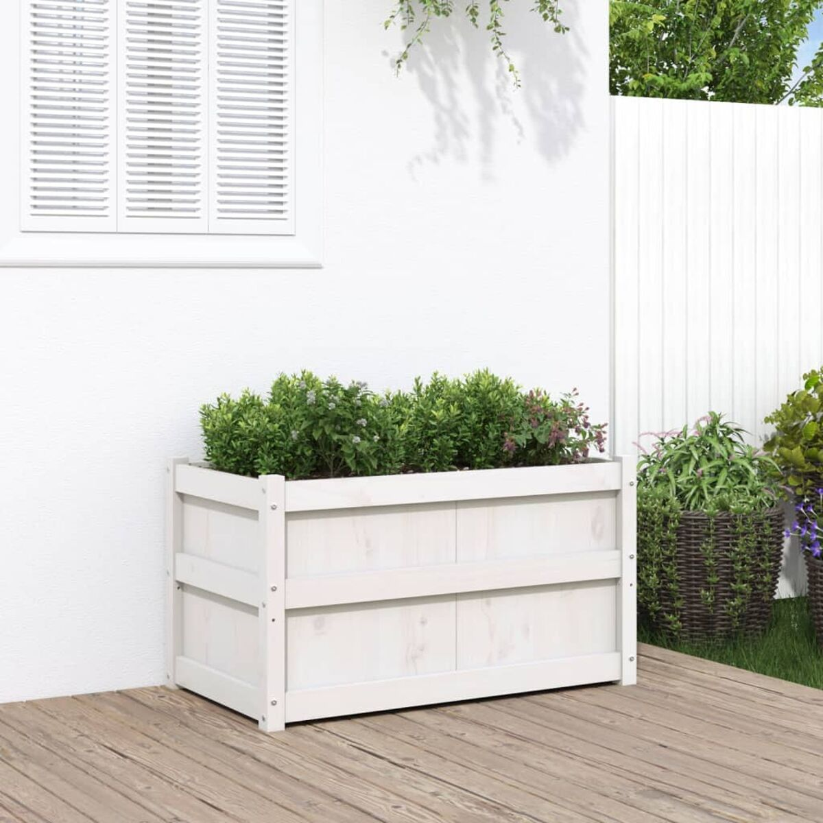 Ein rechteckiger Holzpflanzer mit grünen Pflanzen darin. Er steht auf einem Deck. Dahinter eine weiße Wand.