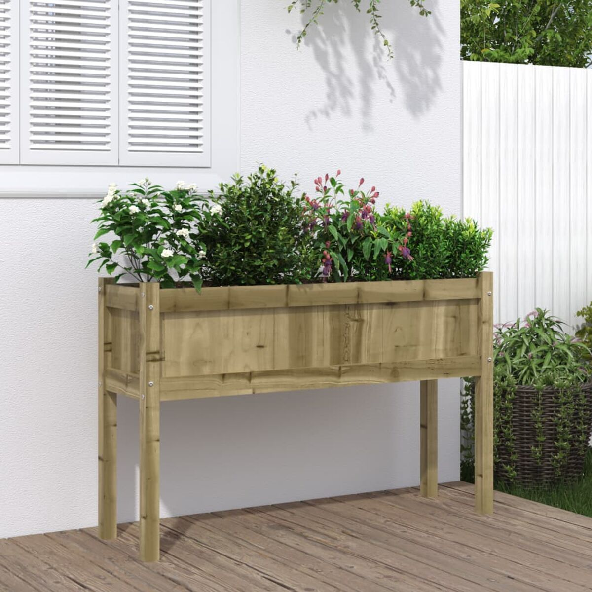 Ein hölzerner Pflanzkasten mit Pflanzen auf einem Deck. Eine weiße Wand und ein Fenster sind im Hintergrund.