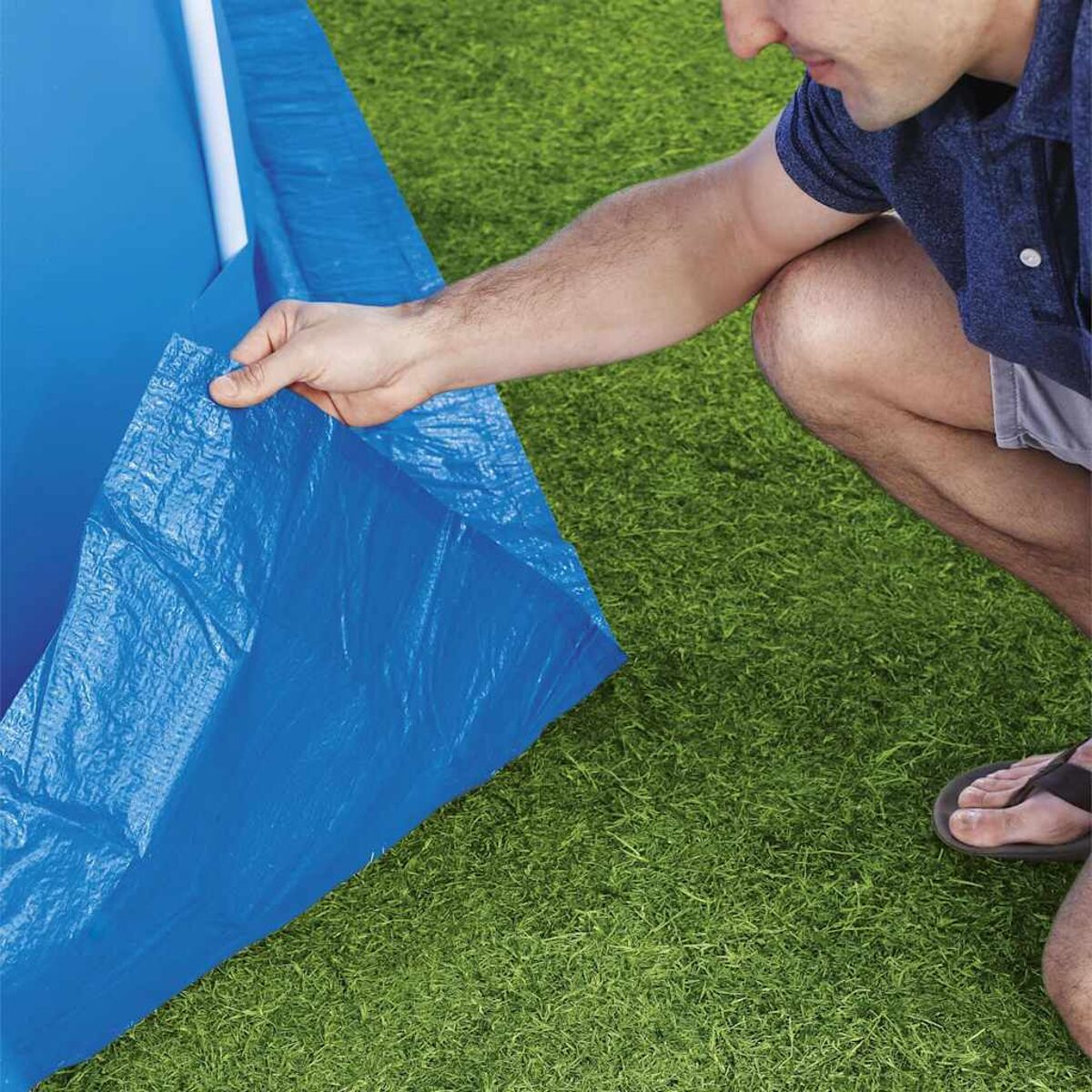 Person kniet, blaue Plane mit Gras.