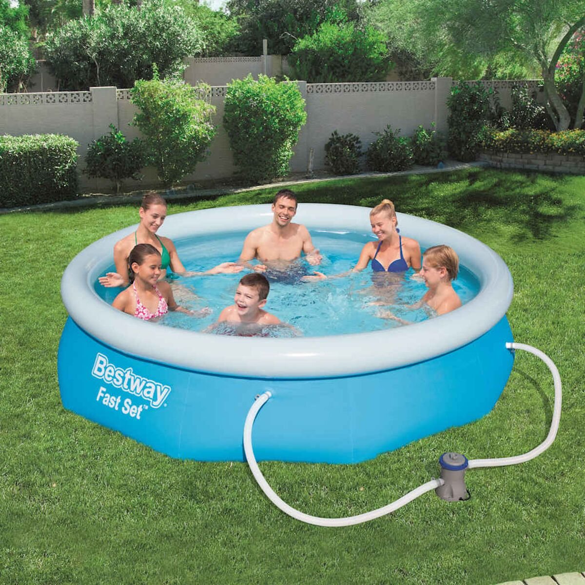 Eine siebenköpfige Familie in einem aufblasbaren Pool in einem grasbewachsenen Hinterhof.