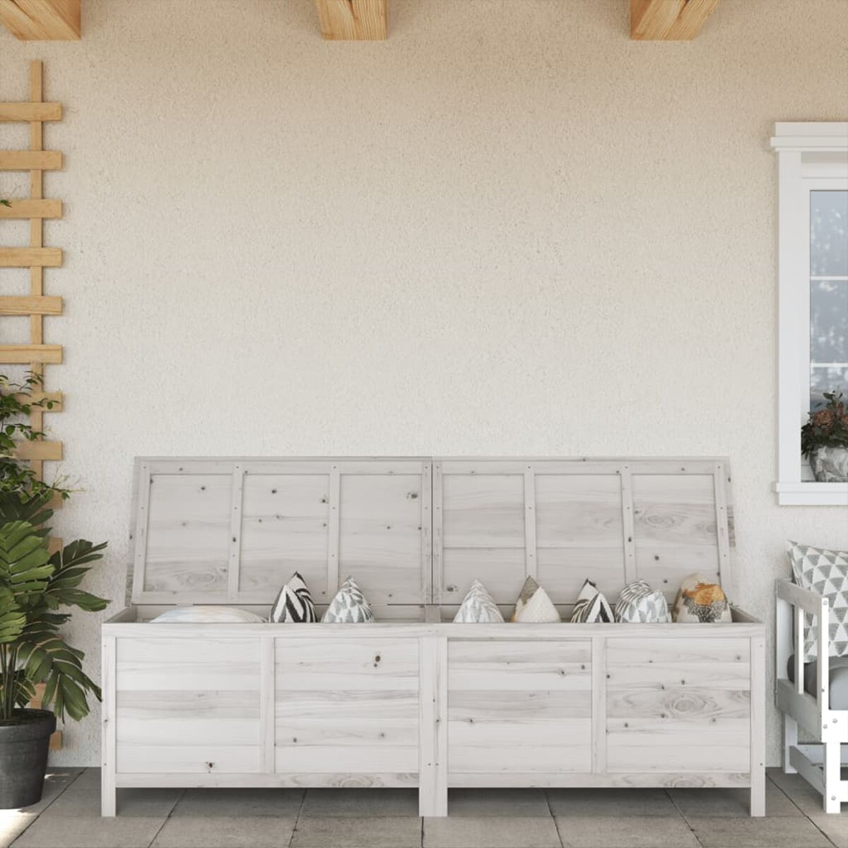Holz-Außenaufbewahrungstruhe mit Kissen. Beige Wand und ein Blumentopf im Hintergrund.