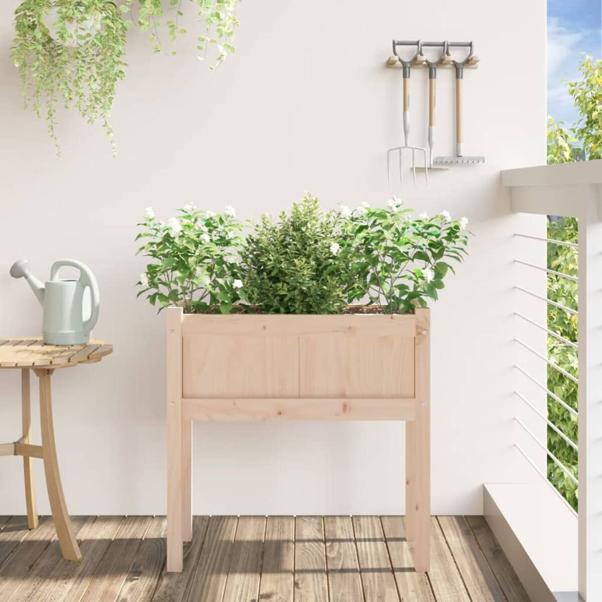 Holzpflanzkasten mit Pflanzen auf einem Balkon. Eine Gießkanne und Gartengeräte sind sichtbar.