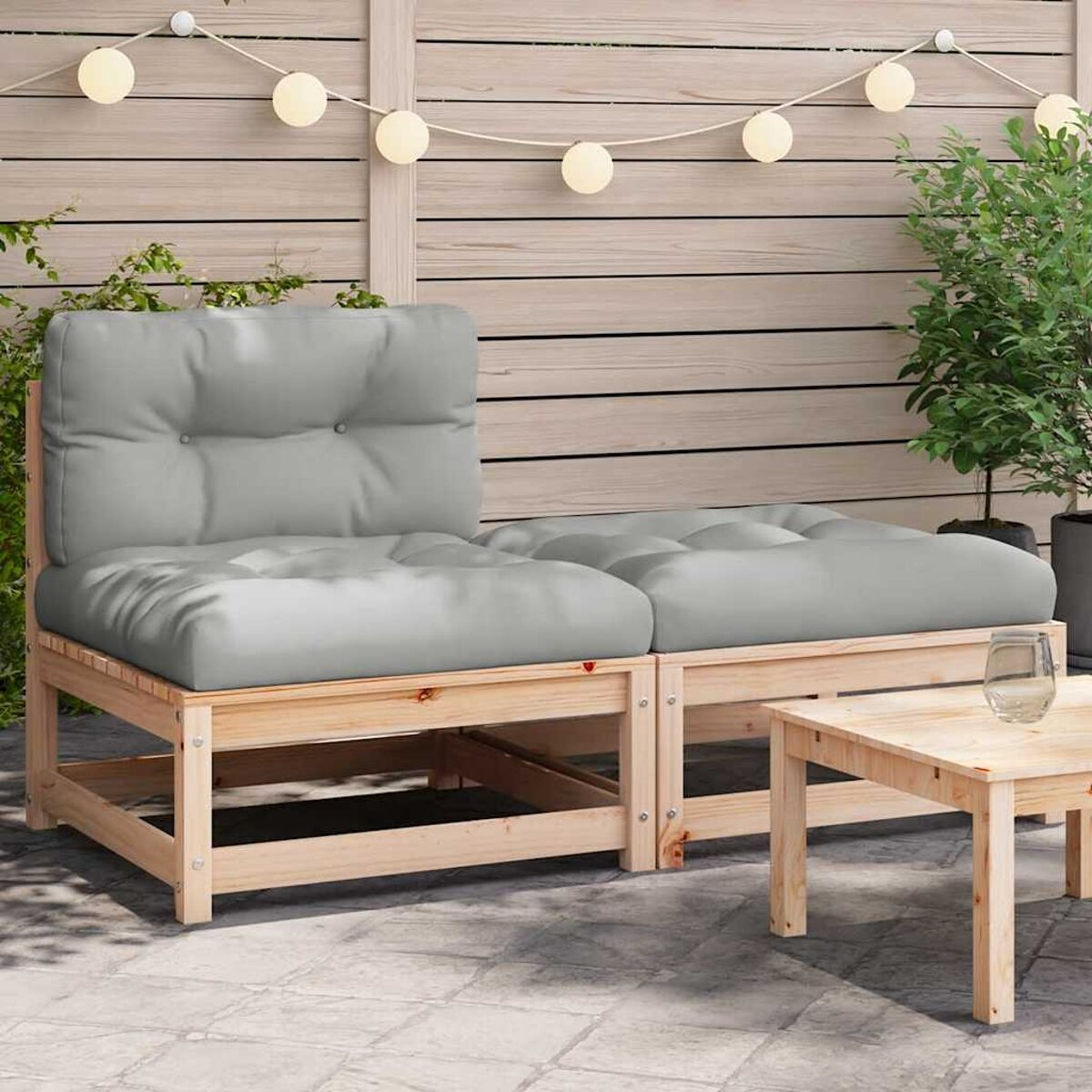 Outdoor-Ecksofa mit grauen Kissen und Holzrahmen. Daneben steht ein kleiner Tisch.