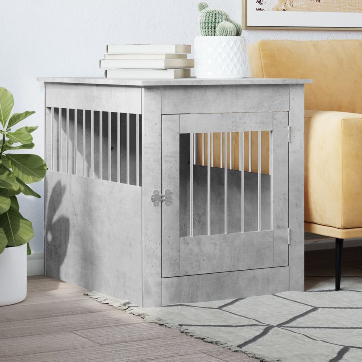 Graue Hundebox mit Tür. Ein Sofa und ein Kaktus sind im Hintergrund.