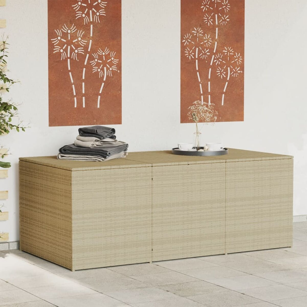 Beige gewebte Outdoor-Aufbewahrungseinheit. Es hat drei Türen und steht auf einer Terrasse. Dekorative Kunst dahinter.