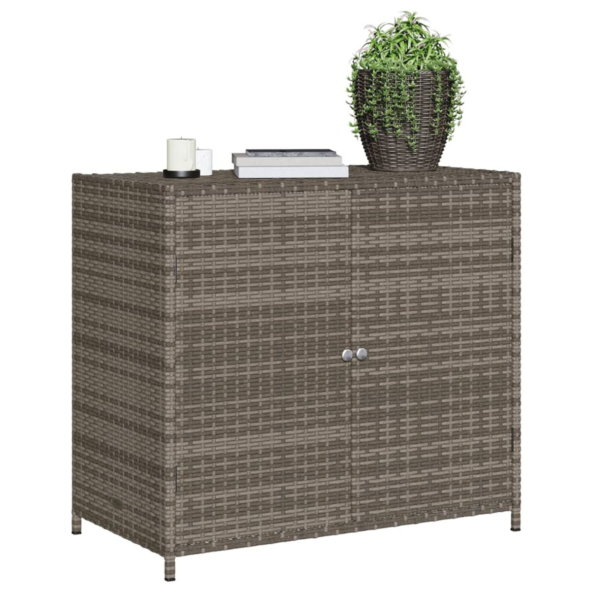 Brauner Rattan-Schrank mit geschlossenen Türen, kleiner Pflanze und Büchern oben drauf.