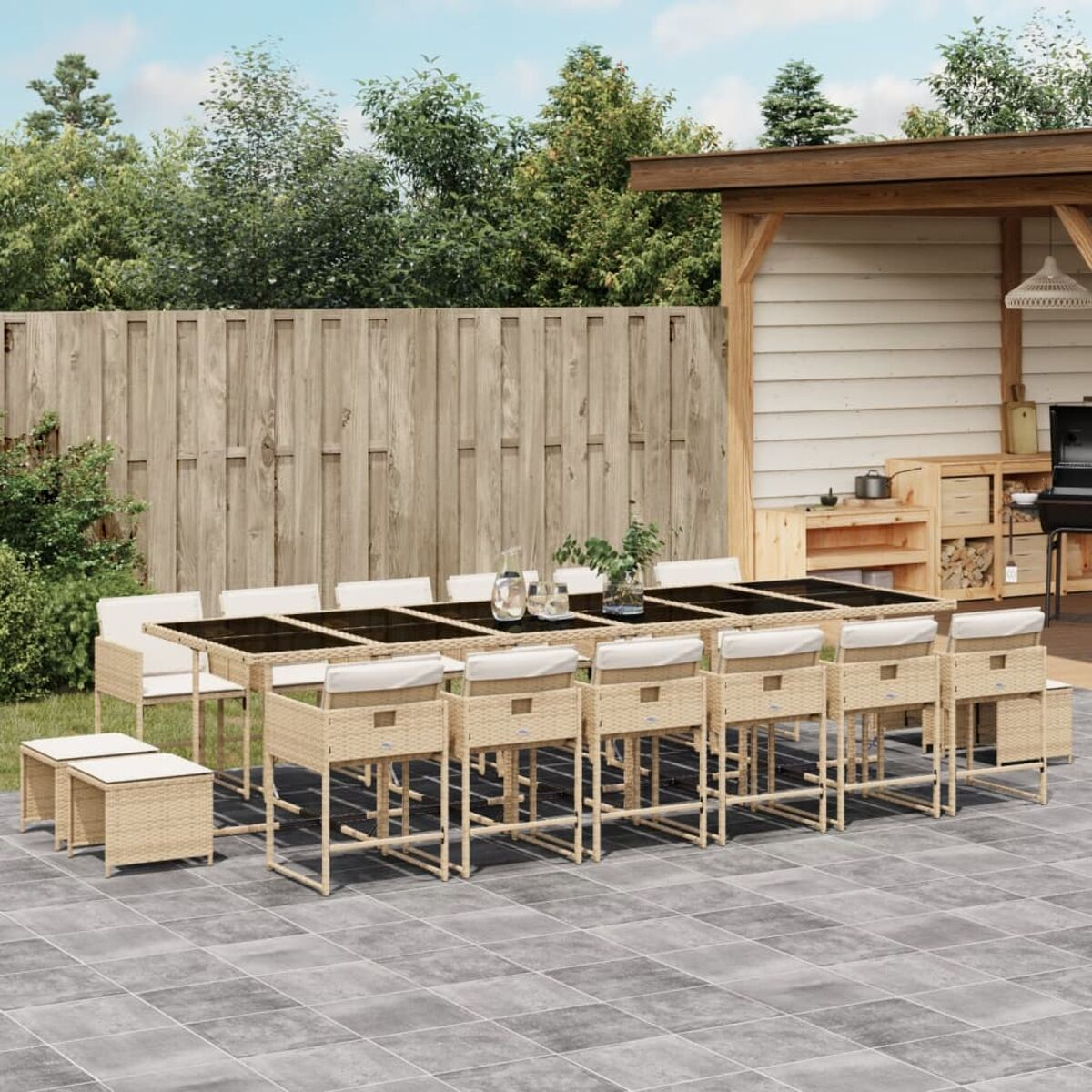 Set da patio all'aperto con sedie beige, tavolo e sgabelli. Lo sfondo include una recinzione e alberi.