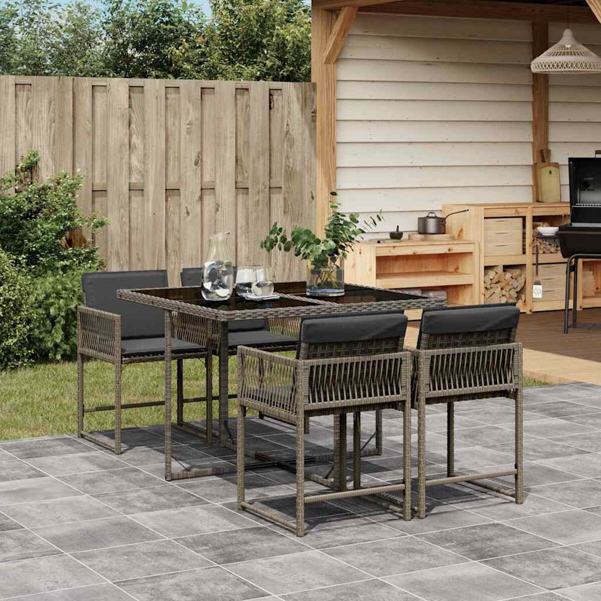Essgruppe im Freien mit quadratischem Tisch und Stühlen, auf einer modernen Terrasse.