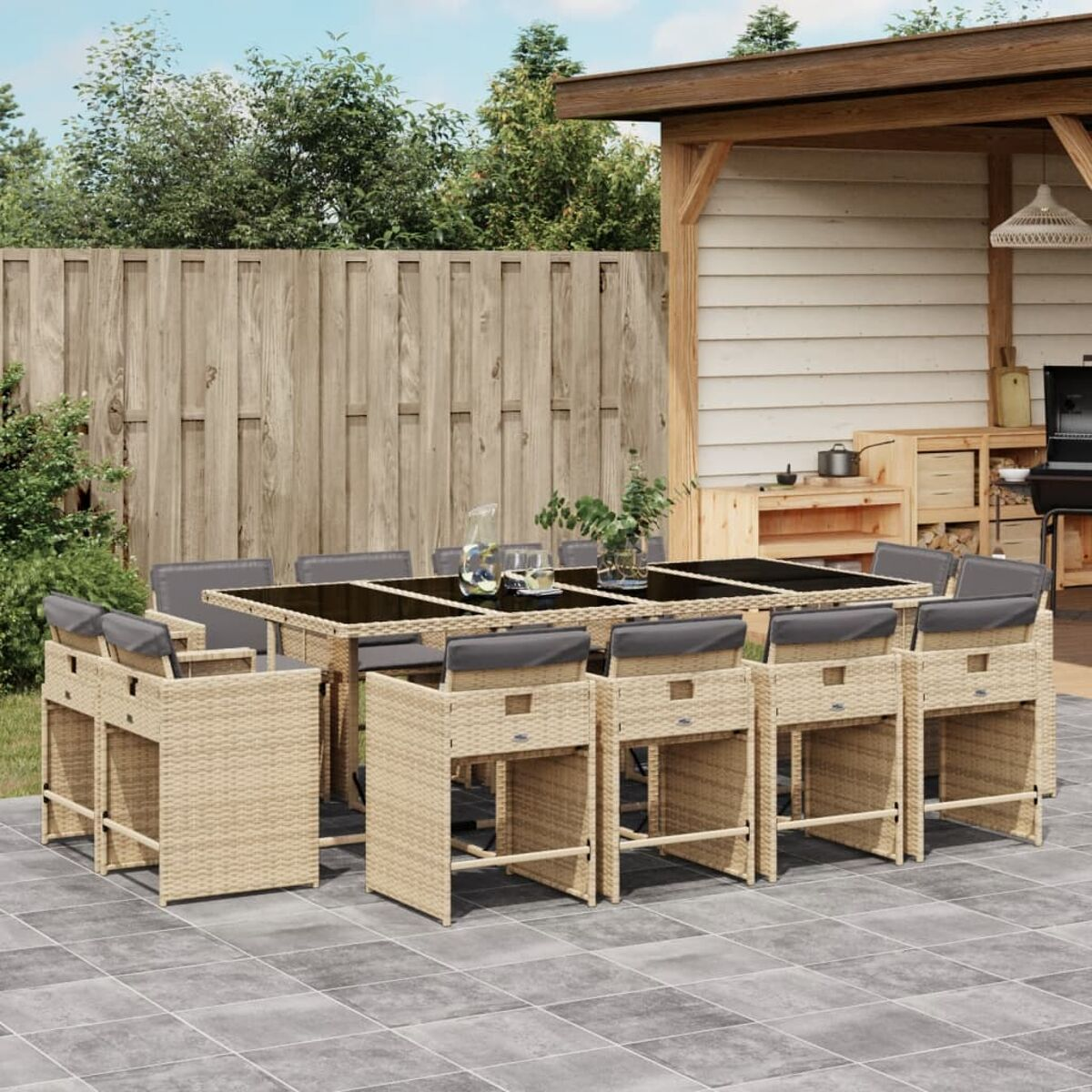 Beiges Ess-Set für den Außenbereich mit Tisch und Stühlen. Der Hintergrund ist eine Terrasse.