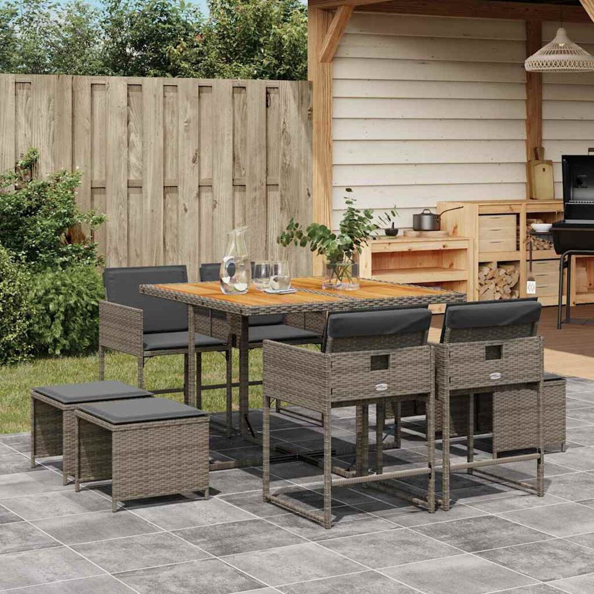 Essgruppe für den Außenbereich mit Tisch, Stühlen und Hockern auf einer Fliesen-Terrasse. Braun.